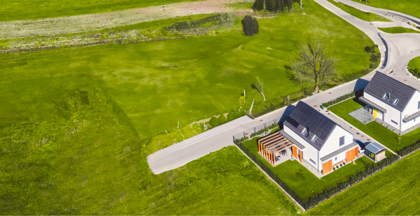 Vue de terrains vacants et de maisons préfabriquées.