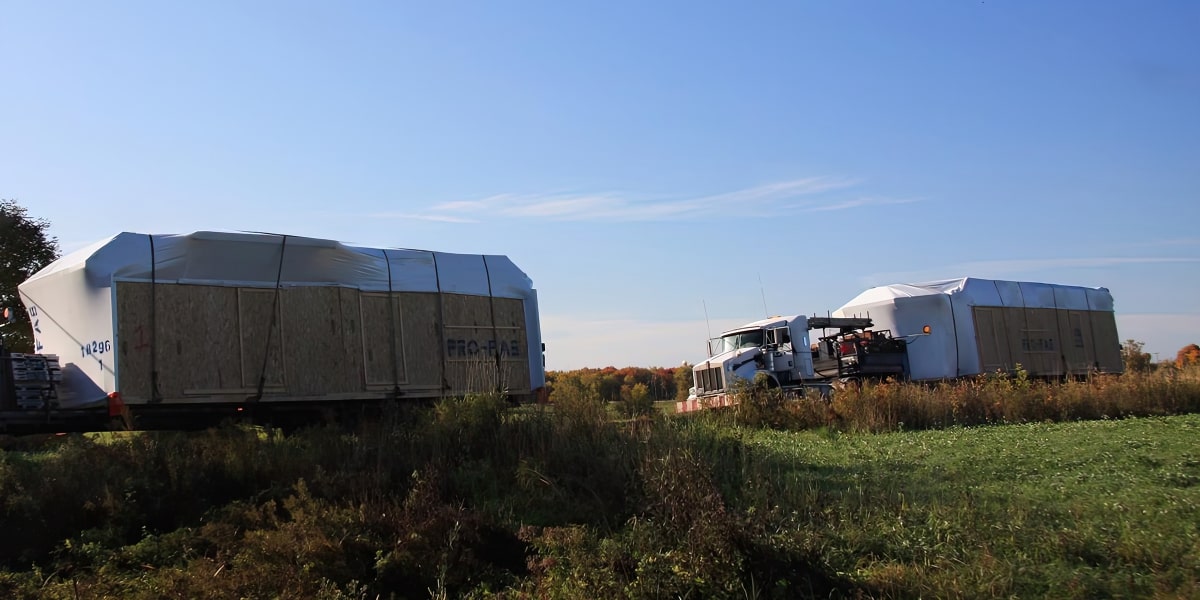 Camion transportant les morceaux d'une maison préfabriquée lors de la livraison.