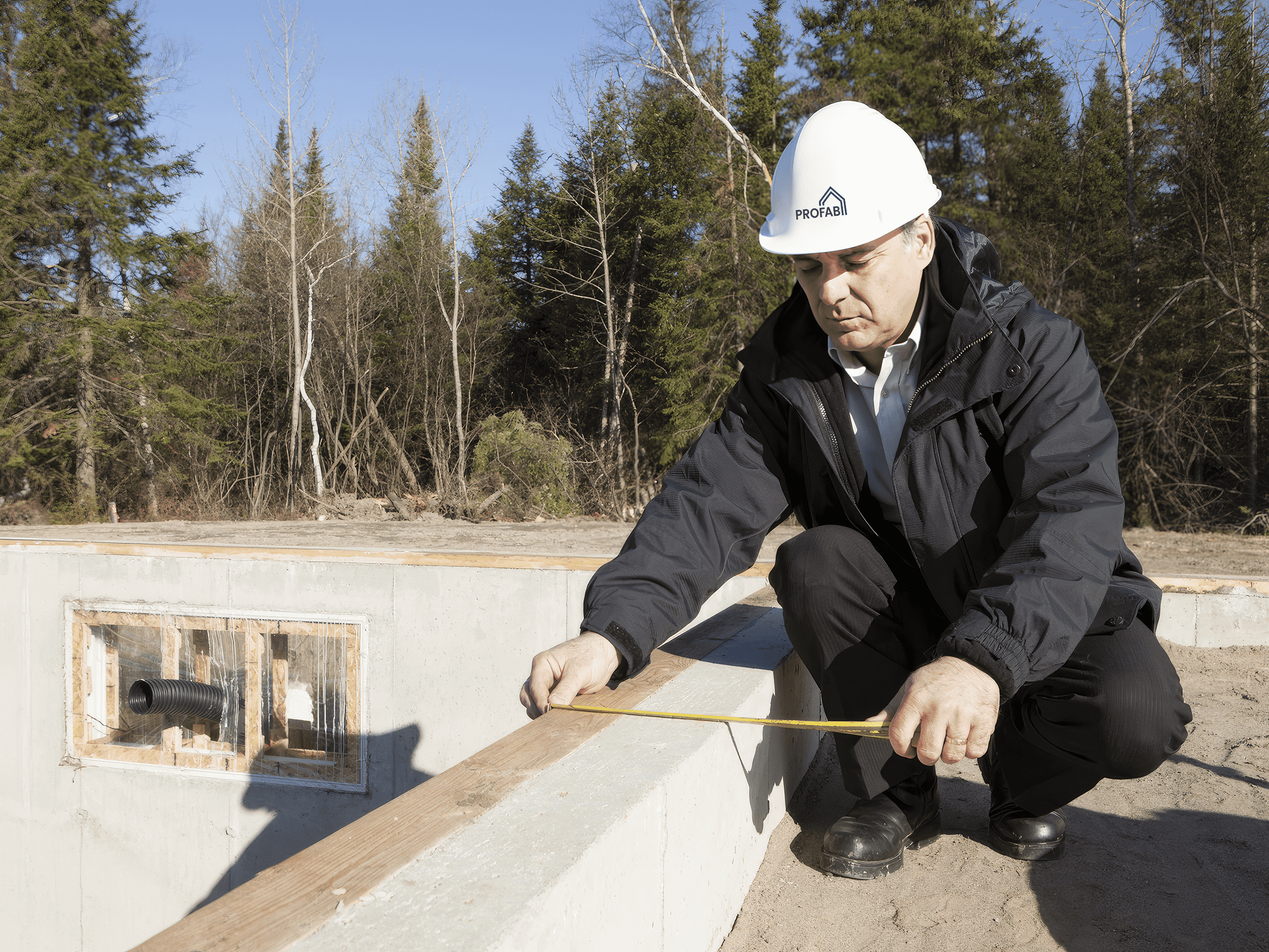 Engineer inspecting the fondation of the prefabricated multi-lodging house.