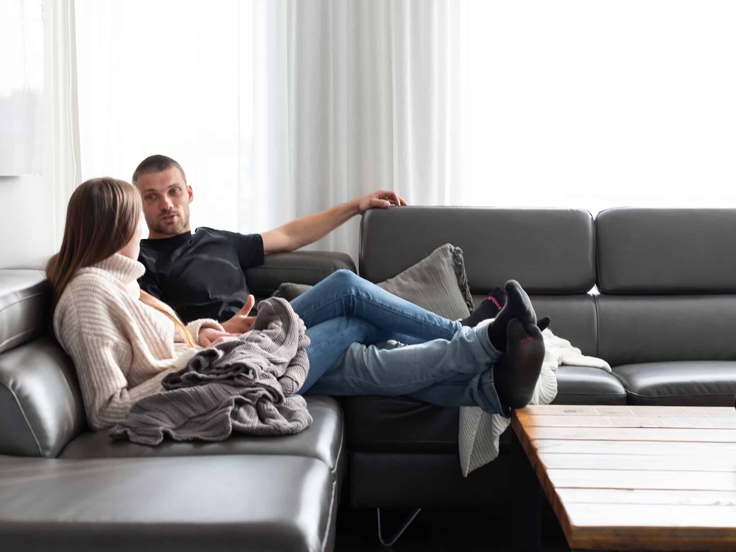 A couple sitting on a sofa in a rented house