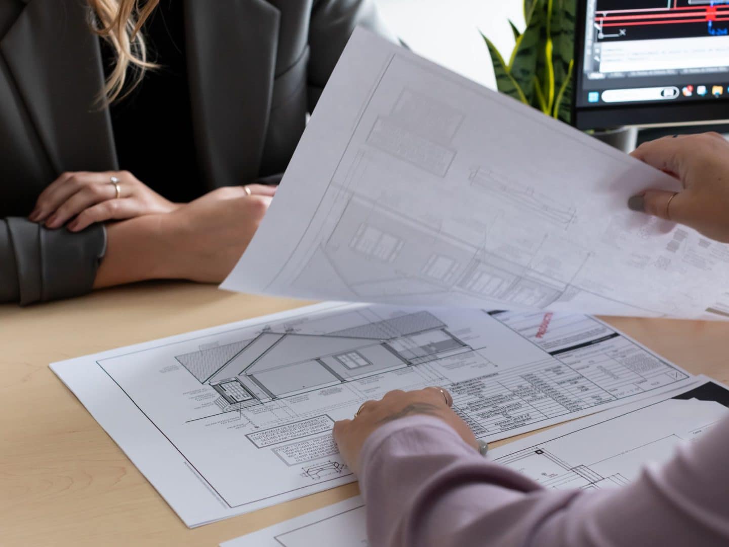 2 people looking at house plans of a prefabricated house