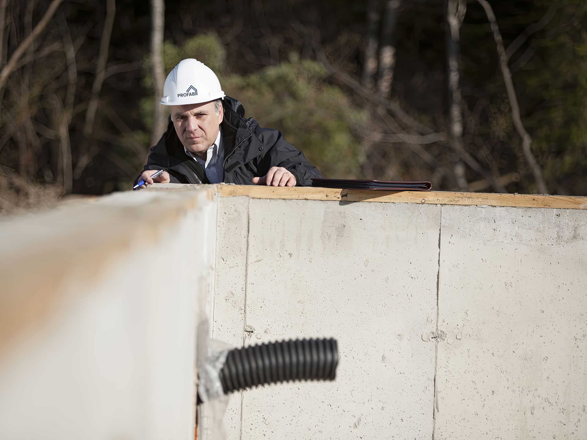 Inspector evaluating the foundations of a prefabricated house