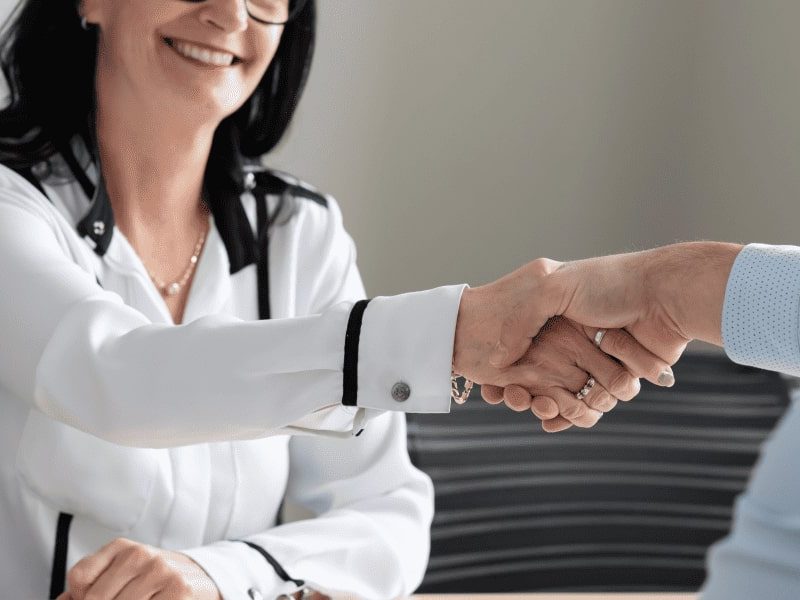 A woman and a man shaking hands.