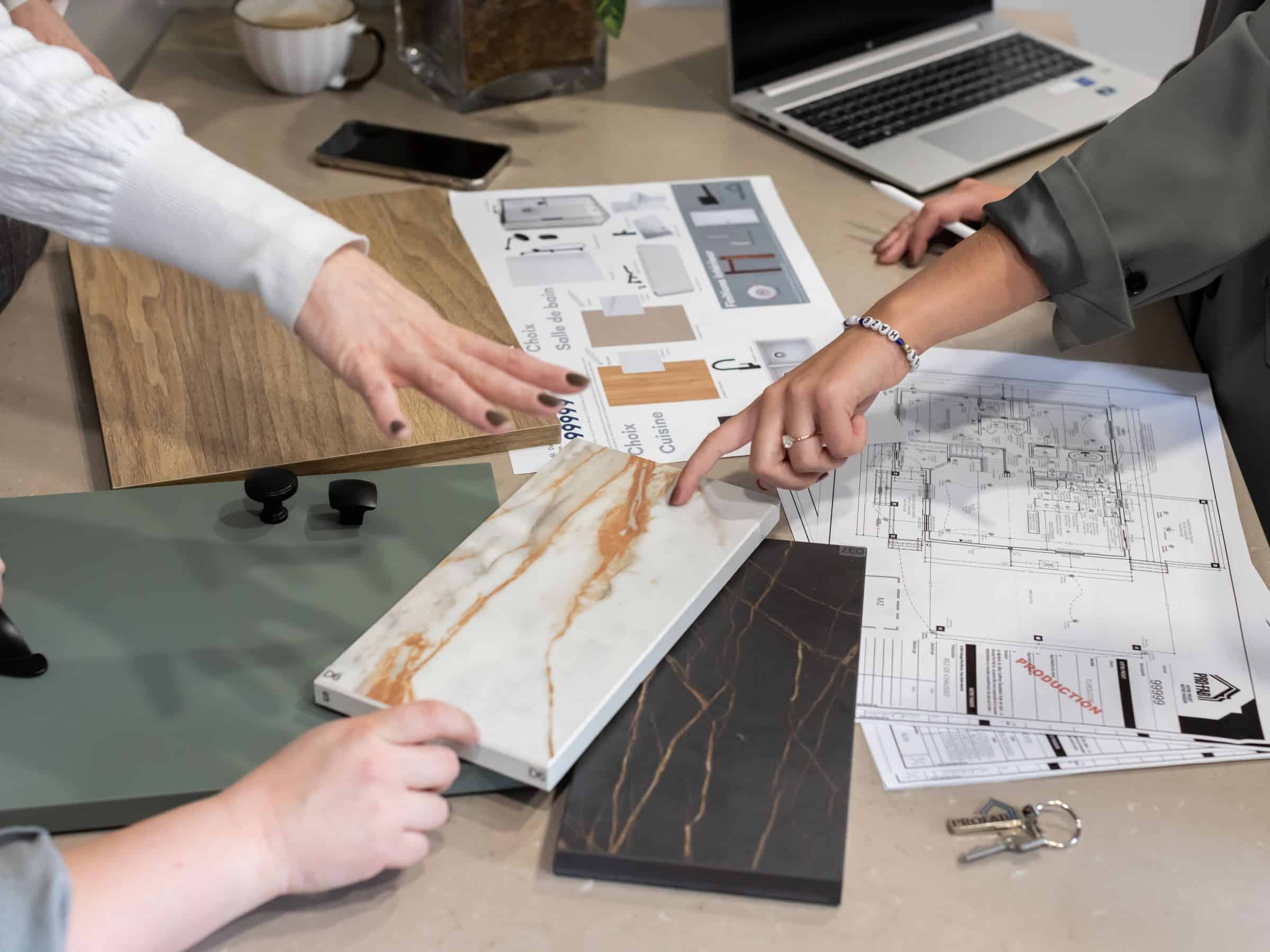 Plans et échantillons pour la construction d'une maison préfabriquée disposée sur une table.