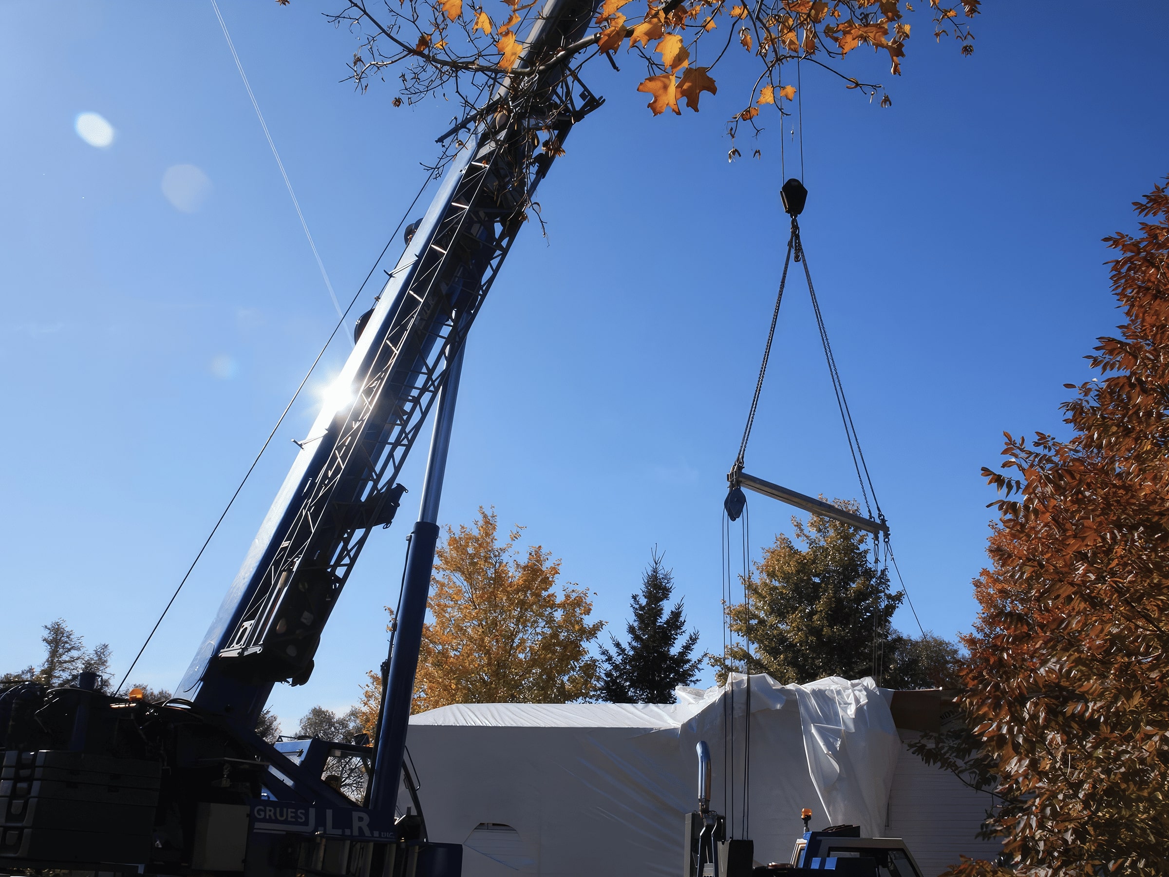 Grue déposant les morceaux d'une maison préfabriquée lors de la livraison.