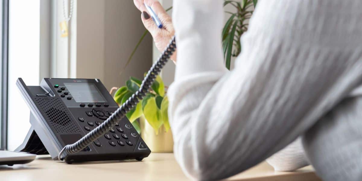 Femme vue de dos parlant au téléphone concernant sa garantie après-vente.