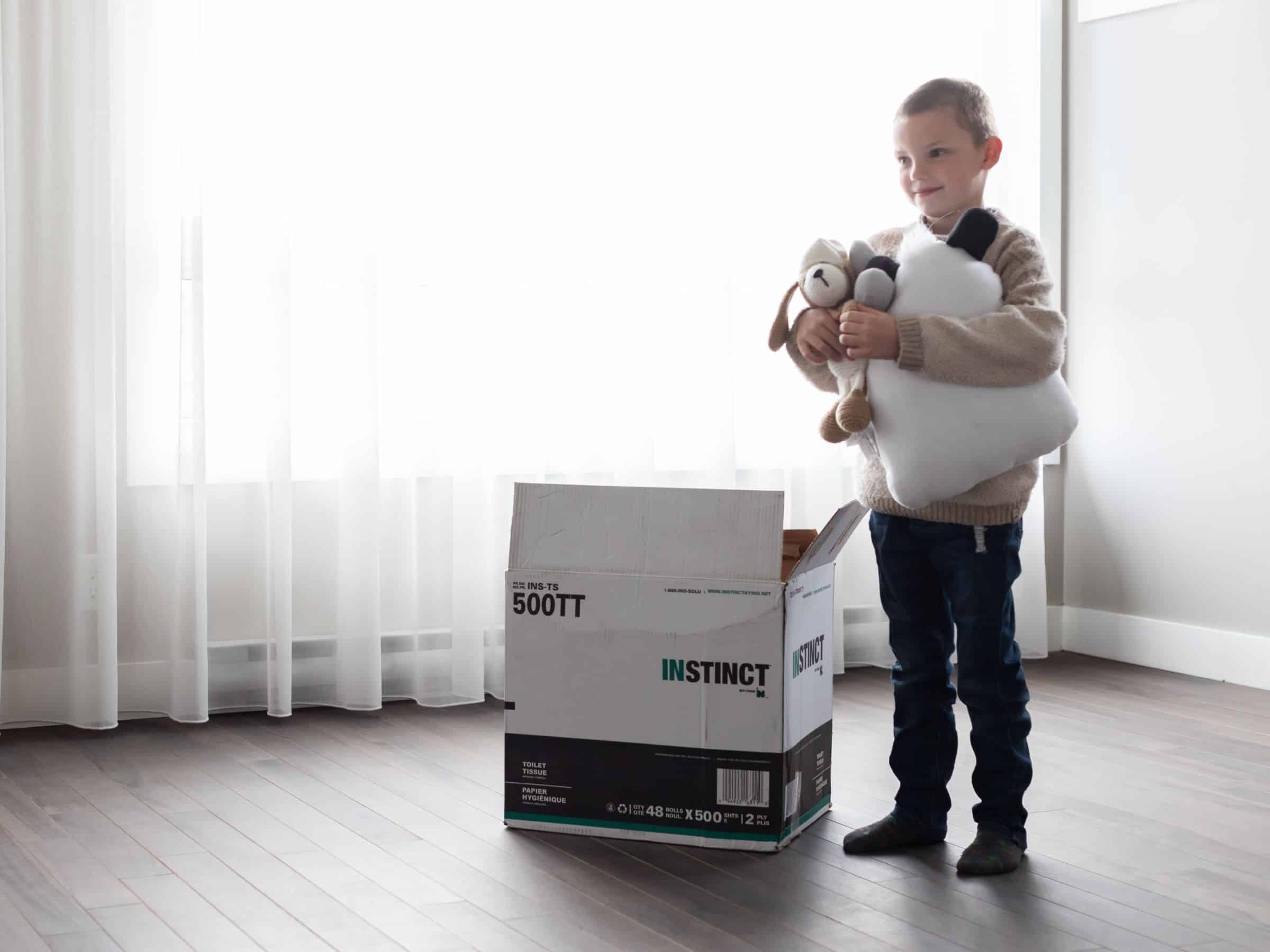 a child happily unpacking moving boxes.