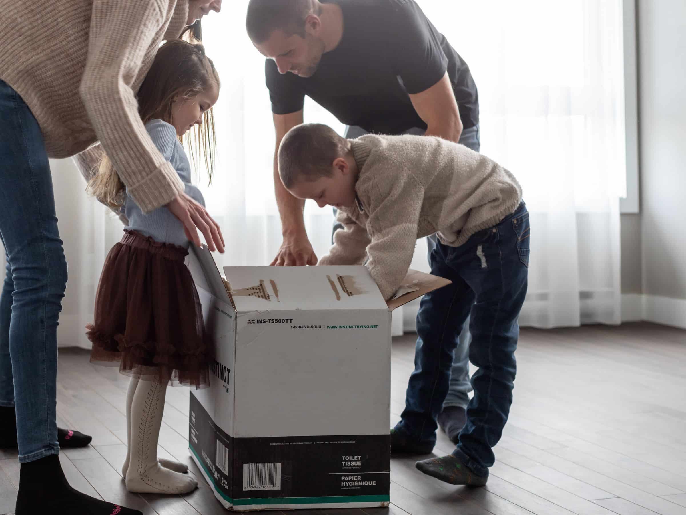 Une famille en train de défaire des boites de déménagement.