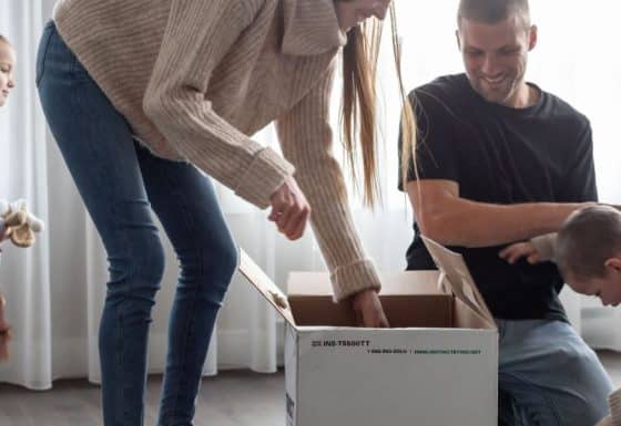 Une famille en train de défaire des boites de déménagement.