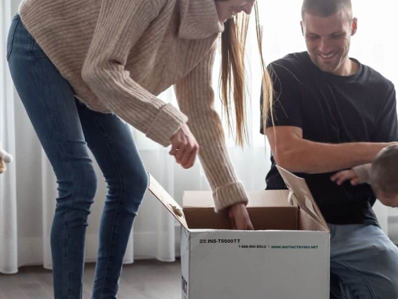 Une famille en train de défaire des boites de déménagement.