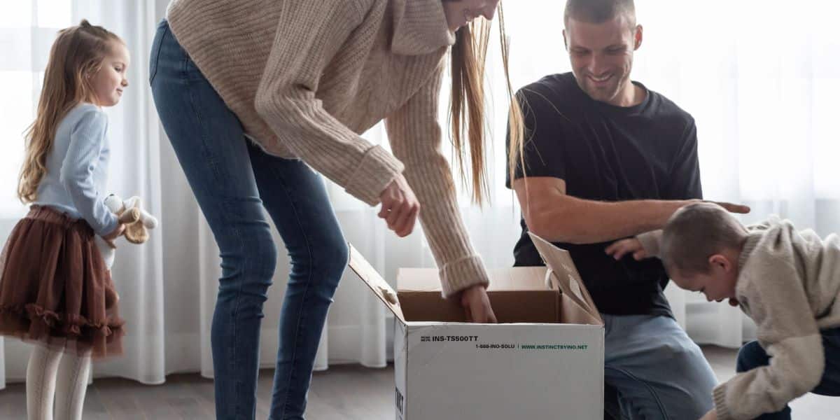 Une famille en train de défaire des boites de déménagement.