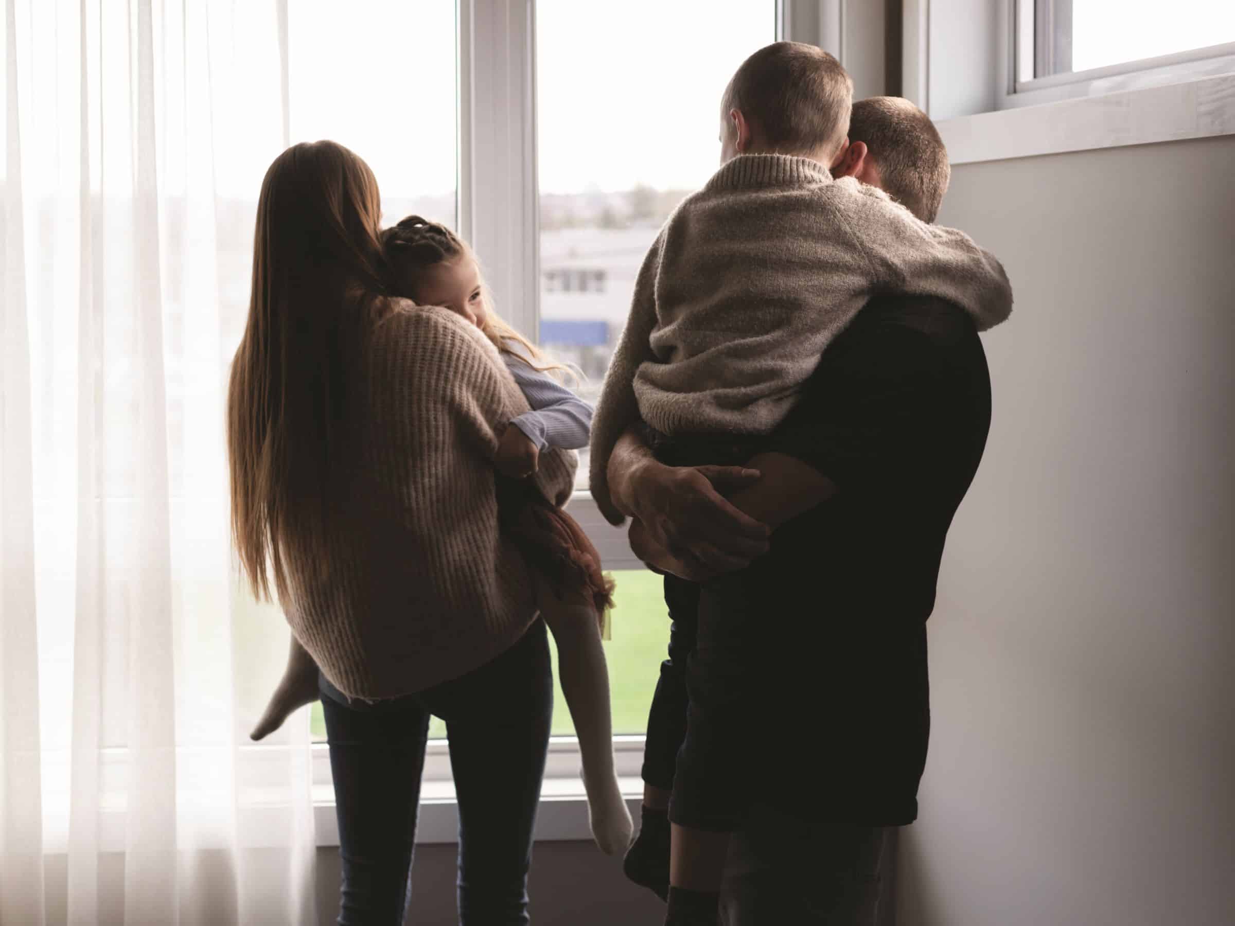 Une famille regardant par la fenêtre.