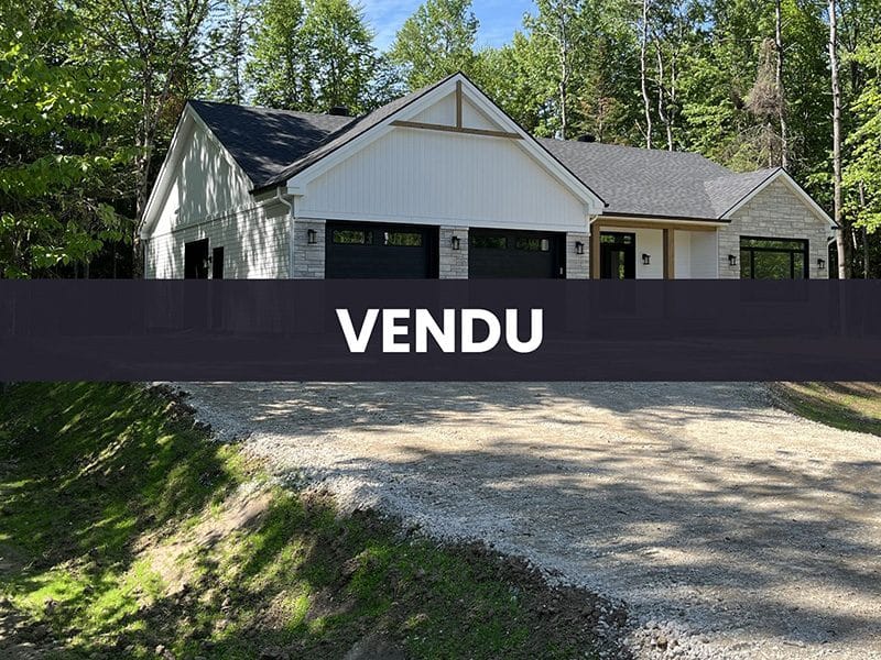 Une réalisation d'une maison ProFab d'un prestigieux plain-pied de style farmhouse contemporain construit sur mesure. Vu extérieur avec mention VENDU