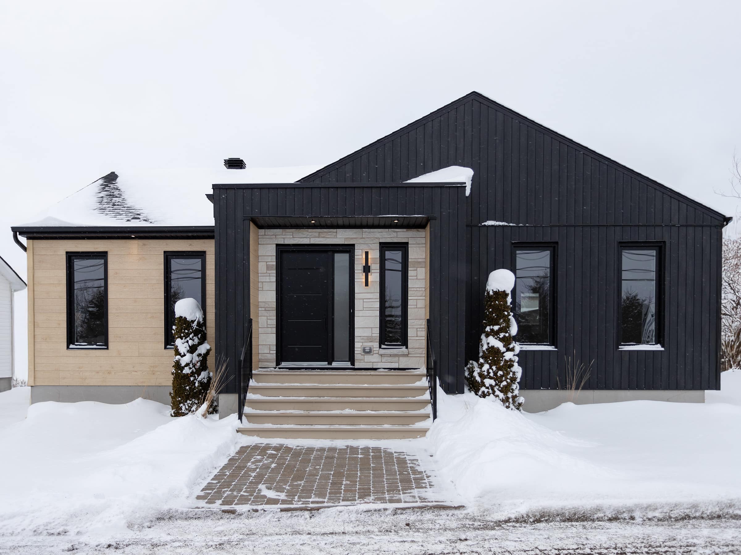 Une maison de plain-pied appelée Emile. Le premier étage est de style contemporain, vu de l'extérieur.
