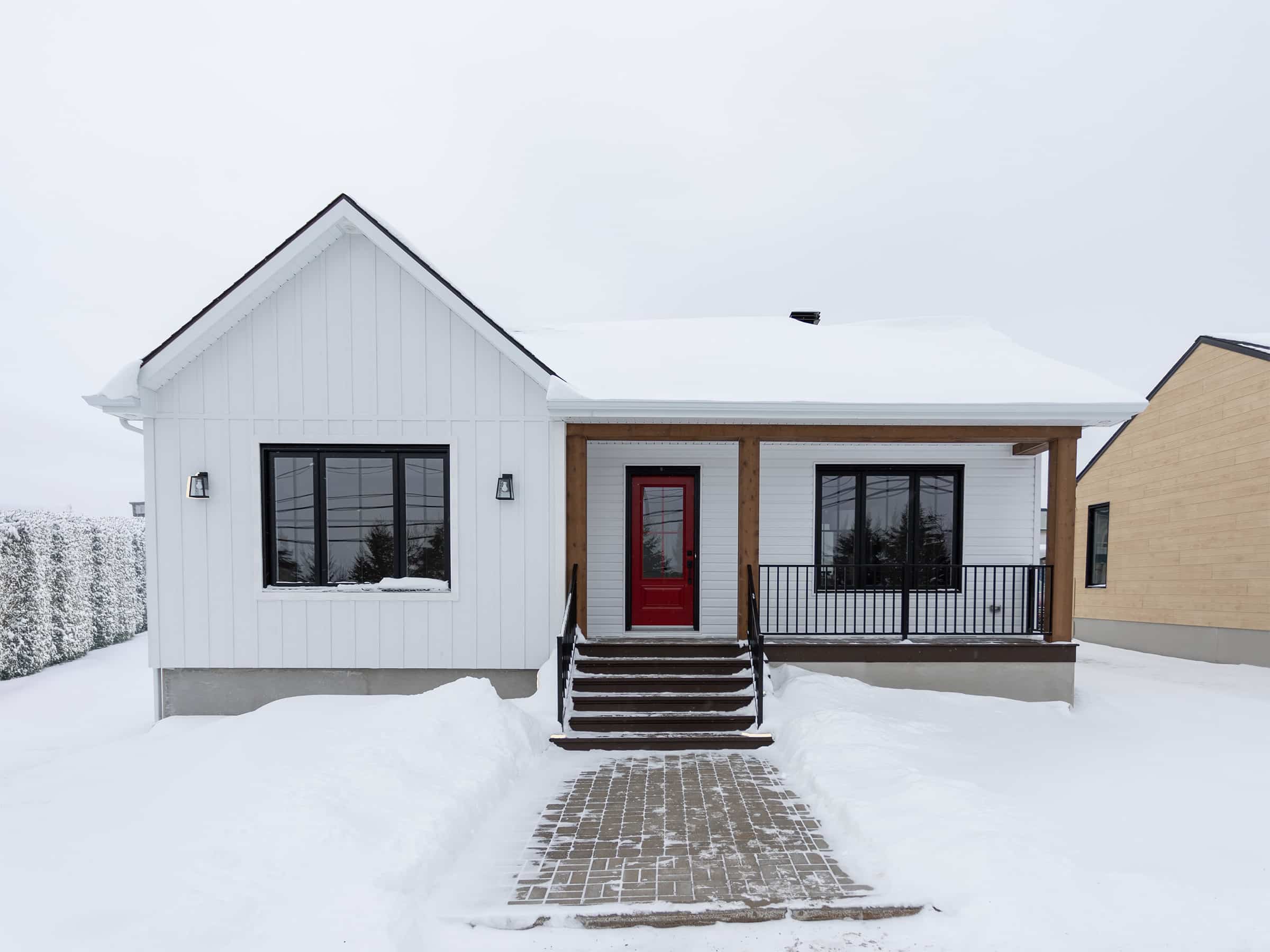 Maison plain-pied préfabriquée de réalisation du modèle Courtoise de style Farmhouse. Vue de l'extérieur.