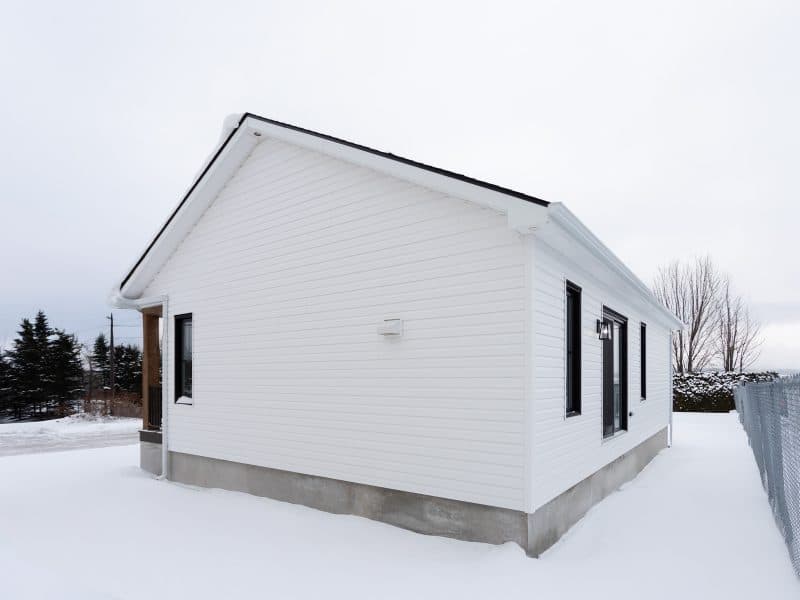 Maison plain-pied préfabriquée de réalisation du modèle Courtoise de style Farmhouse. Vue de l'extérieur.