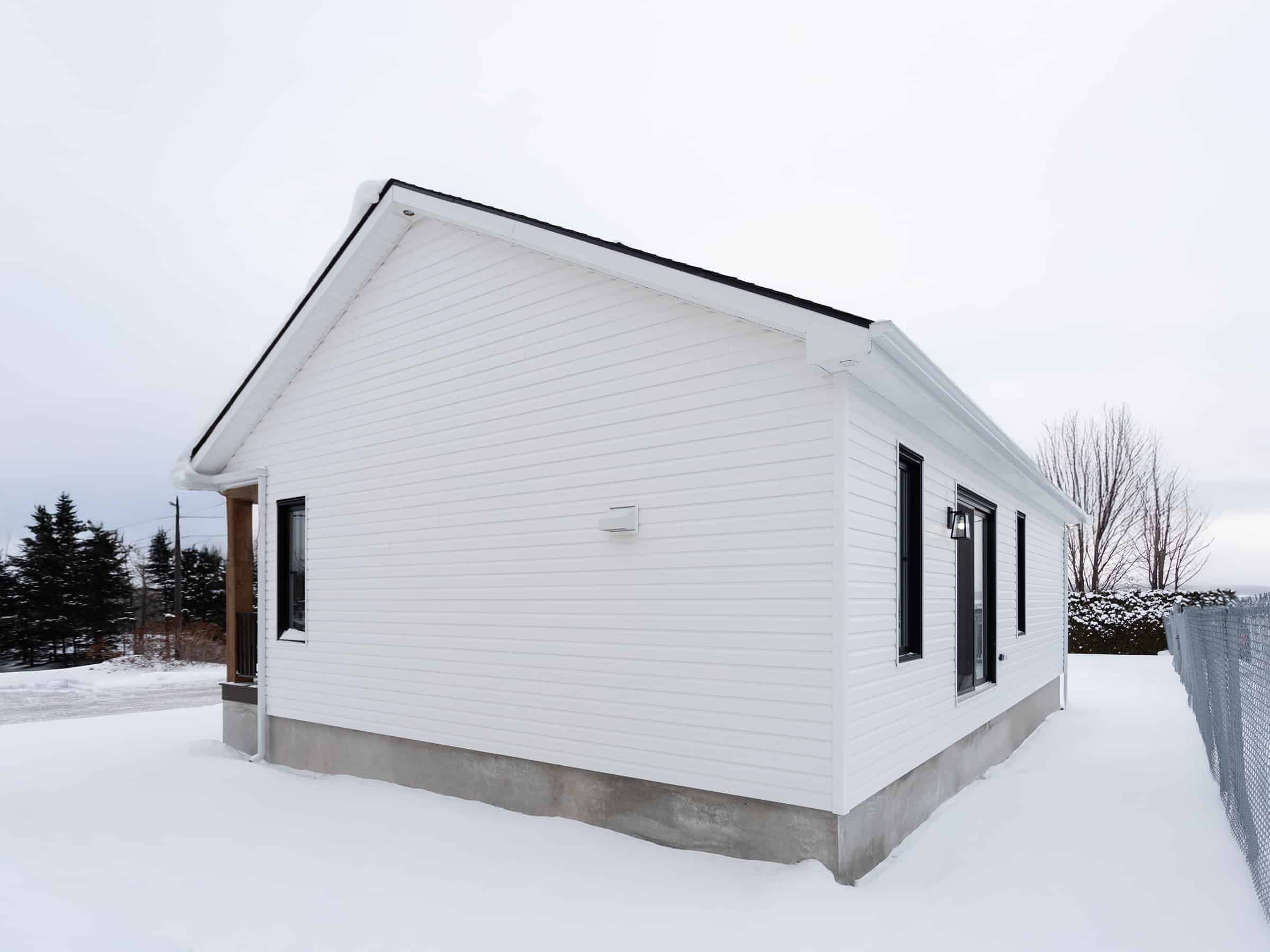Maison plain-pied préfabriquée de réalisation du modèle Courtoise de style Farmhouse. Vue de l'extérieur.