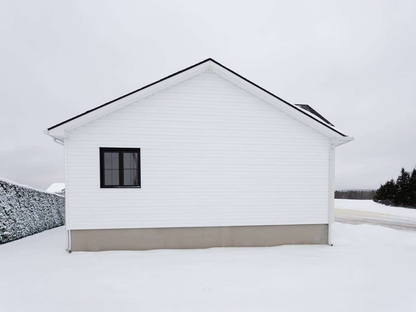 Maison plain-pied préfabriquée de réalisation du modèle Courtoise de style Farmhouse. Vue de l'extérieur.