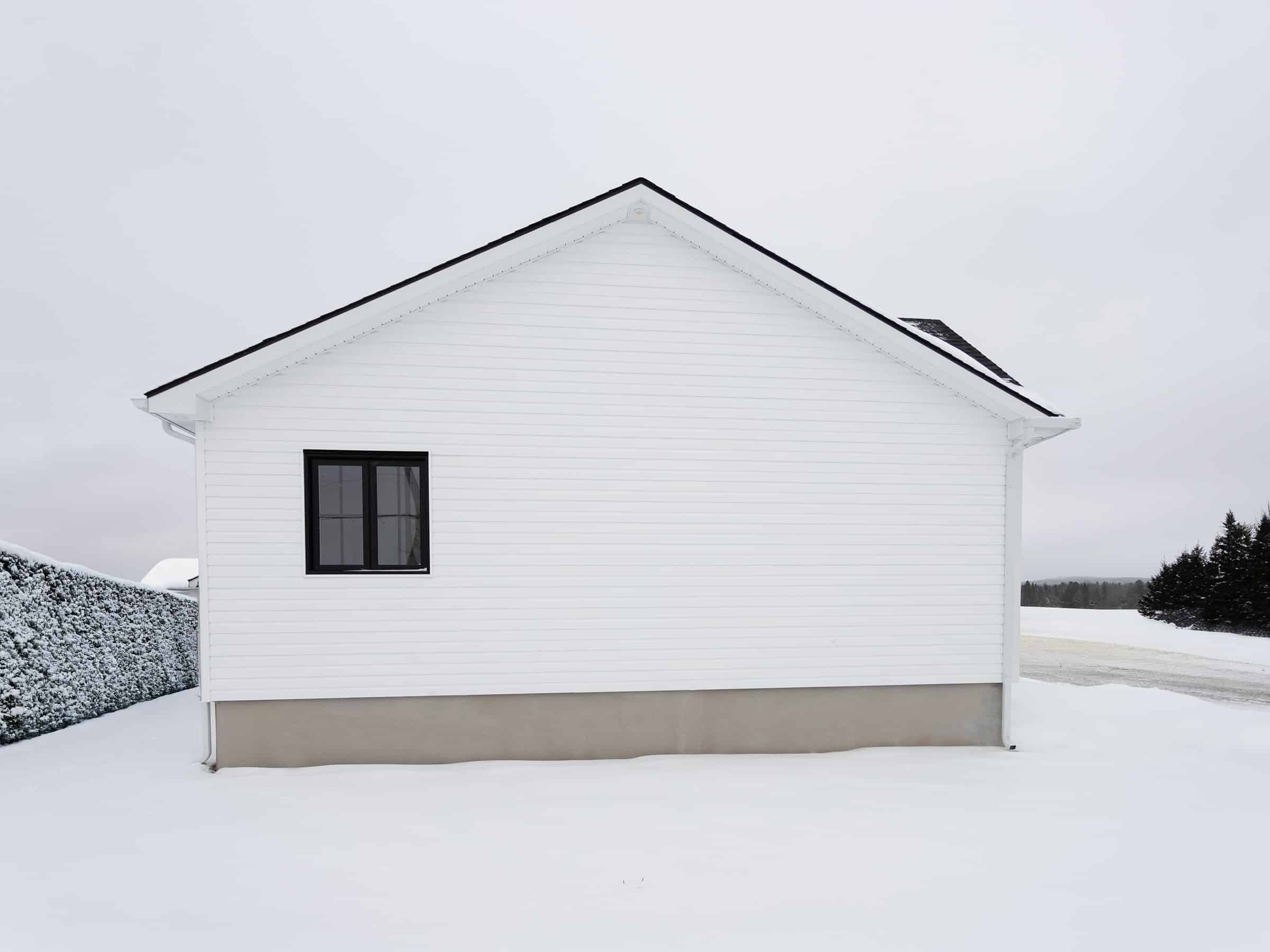 Maison plain-pied préfabriquée de réalisation du modèle Courtoise de style Farmhouse. Vue de l'extérieur.