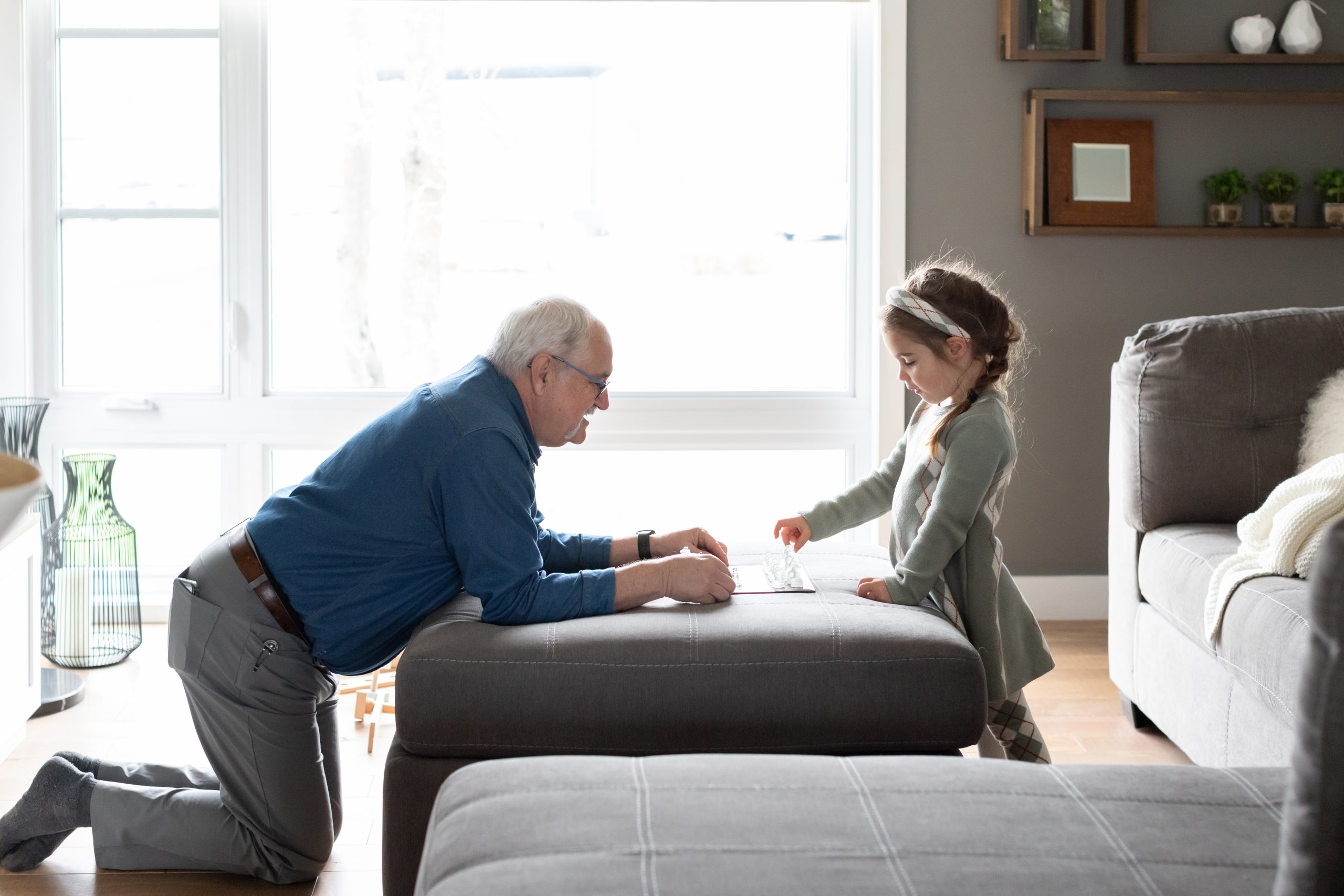 Un grand-père avec sa petite fille qui joue au échec
