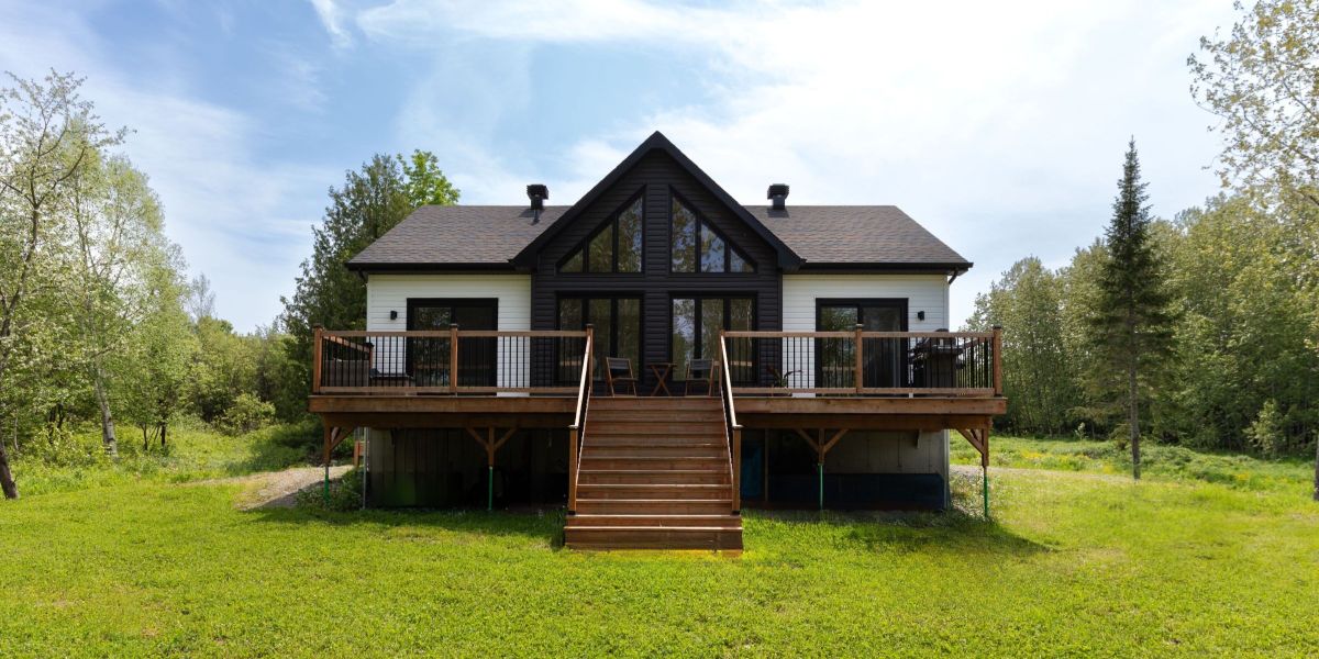 Une réalisation d'une maison préfabriquée appelée Merle. Cette réalisation client est de style Chalet contemporain, vu du salon.