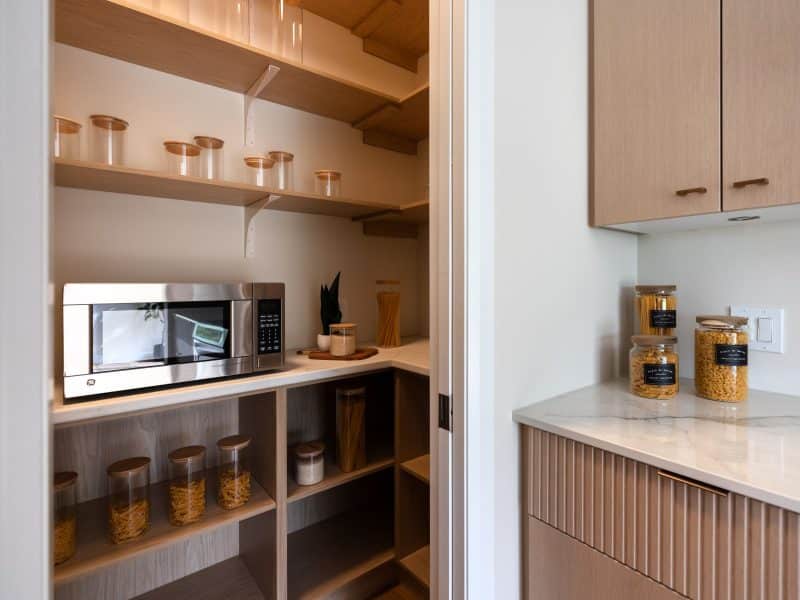 Modèle Edena, une maison usinée à deux étages au style farmhouse moderne et spacieuse. Vu du garde-robe de la cuisine.